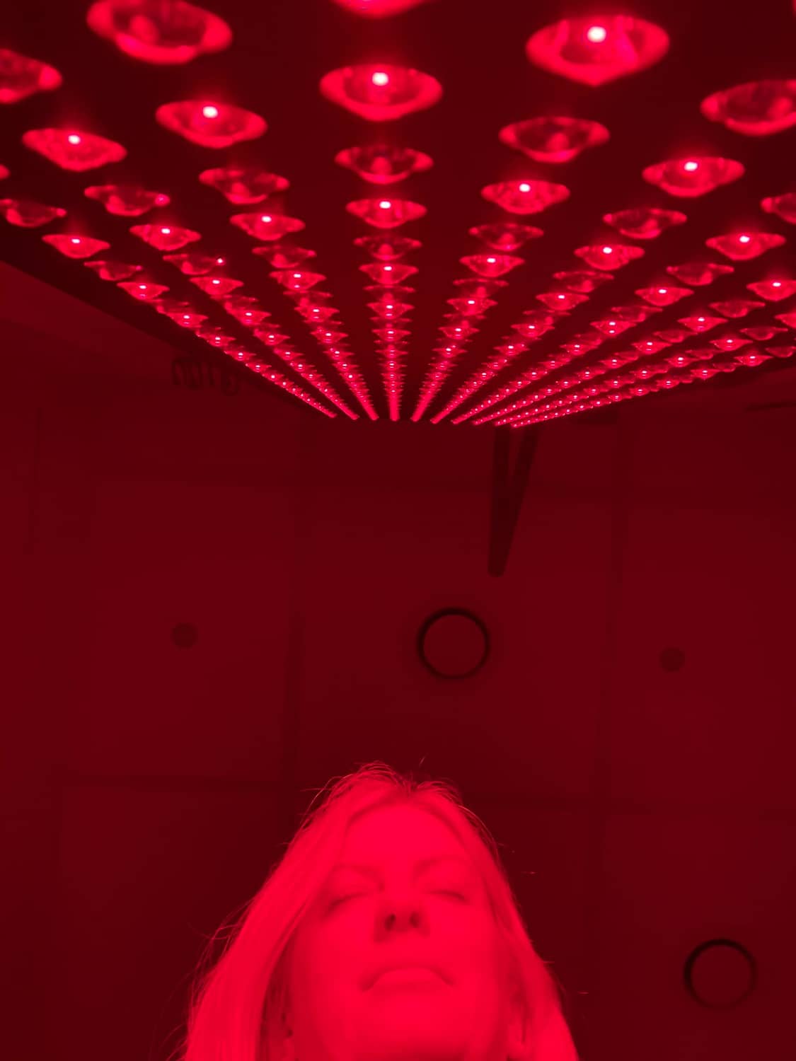 Lady infront of a Red Light Therapy Panel