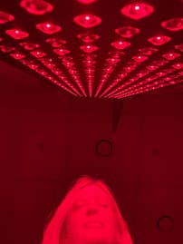Lady infront of a Red Light Therapy Panel