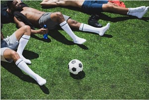 Football players having a rest after Sports Rehabilitator treatment