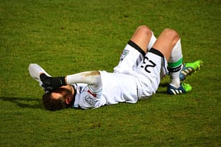 Footballer lying on the pitch with injury